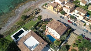 Vista aerea di una zona residenziale con case, una piscina e una costa ben definita.
