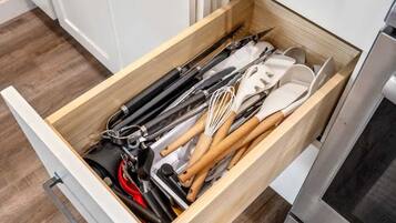 A kitchen drawer with various utensils and kitchen tools.