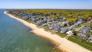 An aerial view of a coastal residential area with houses, a beach, and a body of water. - Popponesset-3-bedrooms, 3.5 baths, sleeps 6, A/C, Pool, Firepit (Mashpee)