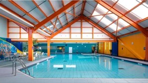 An indoor swimming pool with a high ceiling and a skylight. - Modern & Blissful Beach Holiday Park Home in Essex (Harwich)