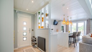 A modern kitchen with a central island, pendant lighting, and a view to the outside. - 2 bedroom accommodation in Benllech (Benllech)