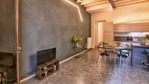 A modern kitchen with a dining area, a fireplace, and a TV. - Appartamento Simone by Theater Home, in the heart of Gargnano (Gargnano)