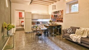A modern kitchen with a dining area, a sofa, and a window. - Appartamento Simone by Theater Home, in the heart of Gargnano (Gargnano)
