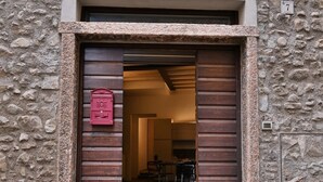 A stone building with a wooden door and a red mailbox. - Appartamento Simone by Theater Home, in the heart of Gargnano (Gargnano)