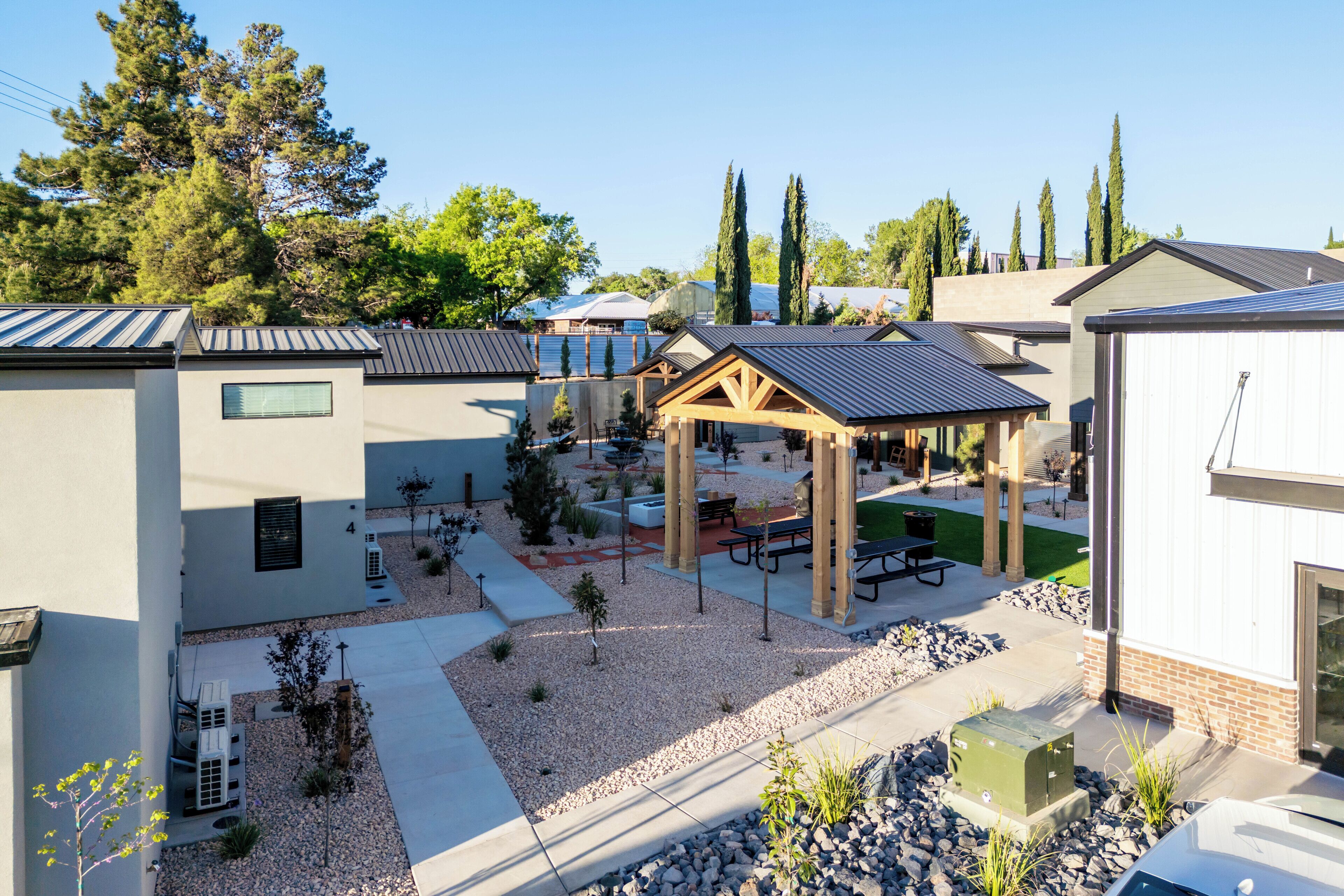 A courtyard with a gazebo, picnic tables, and a small garden area.