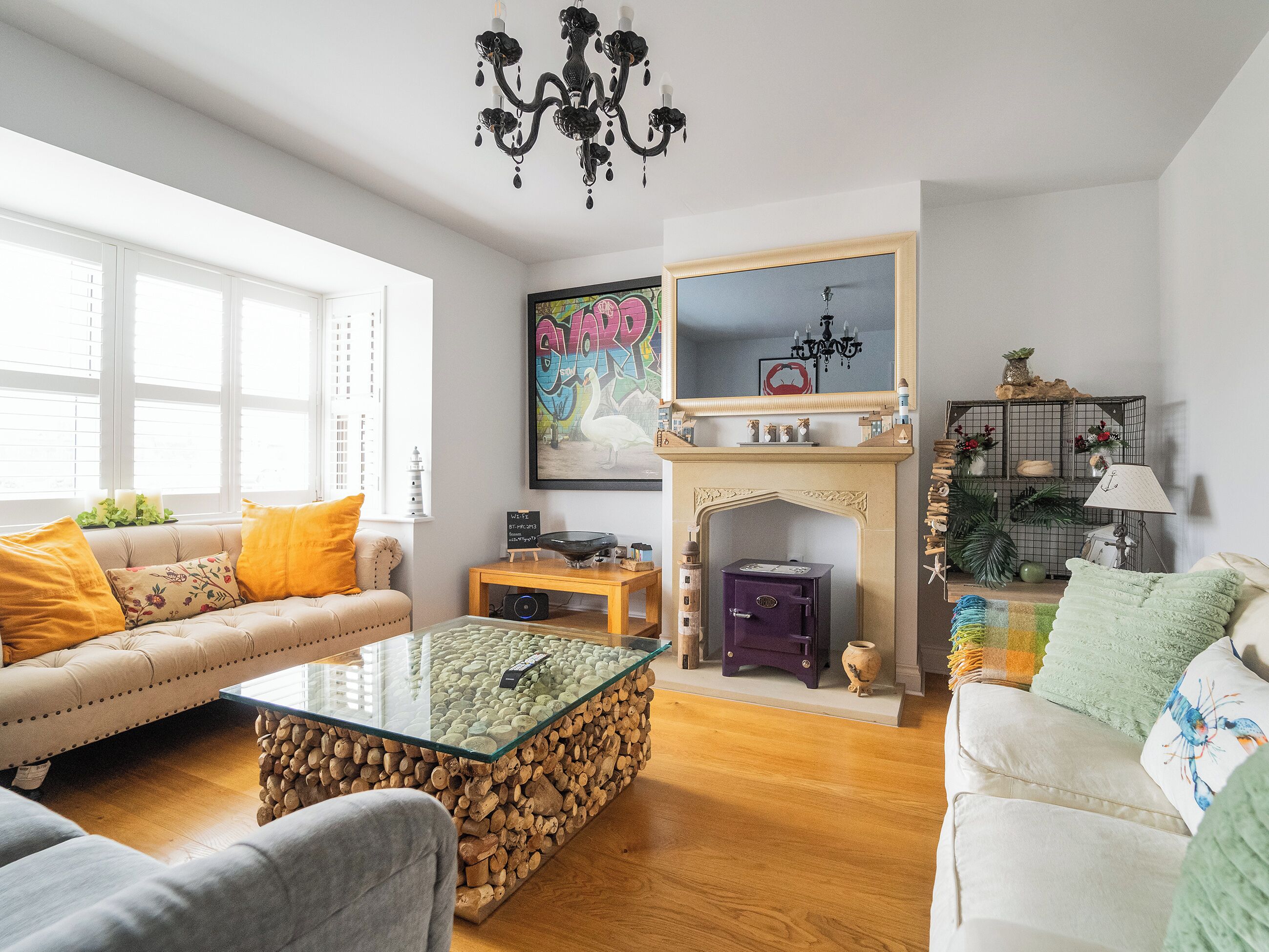 A living room with a fireplace, a sofa, a coffee table, and a bookshelf.