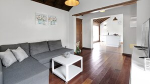 Ein modernes Wohnzimmer mit einem grauen Sofa, einem weißen Couchtisch und einer Holzboden.