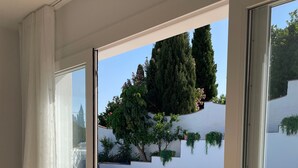 Habitación con vista a una piscina, puerta de cristal y sofá.