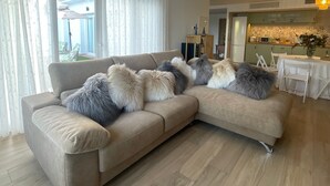 A modern living room with a sectional sofa, a chandelier, and a dining area. - Holiday Home 'Villa Gracia' with Sea View, Wi-Fi and Air Conditioning (Mijas)