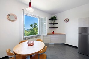Una cocina moderna con comedor, un ventanal y vistas a zonas verdes.