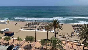 A beach with umbrellas, a lifeguard tower, and a parking area. - Apartment 'Apartamento Frontal Primera Linea' with Sea View, Wi-Fi and Air Conditioning (Fuengirola)