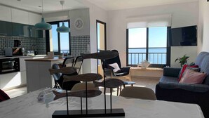 A modern living space with a kitchen, dining area, and seating area with a view. - Apartment 'Apartamento Frontal Primera Linea' with Sea View, Wi-Fi and Air Conditioning (Fuengirola)