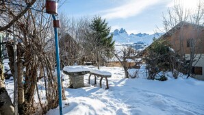 A snowy outdoor area with a stone bench, a metal pole, and a tree. - Apartment 'Chalet -Les Aiguilles- Rdc' with Mountain View, Terrace and Garden (Albiez-Montrond)