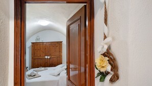 Een kamer met een bed, een houten garderobe en een decoratie aan de muur.