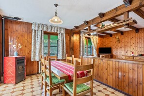Un intérieur en bois comprenant une table à manger, des chaises, un téléviseur et un appareil électroménager rouge.
