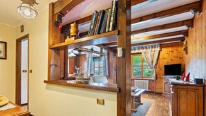 Ein Holzinnenraum mit Küchenzeile, Esstisch und Bücherregal.