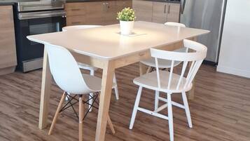 A modern kitchen with wooden cabinets, stainless steel appliances, and a central island with chairs.