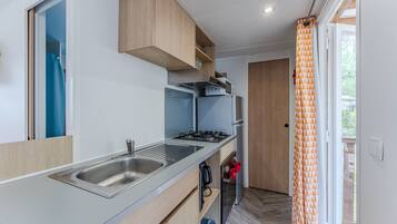 A compact kitchen with a built-in gas stove, a sink, and a small refrigerator.