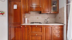Una cocina con armarios de madera, estufa y pileta.