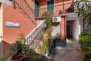 Un bâtiment avec un escalier, une enseigne indiquant « Casa del Cid », et des plantes en pot.