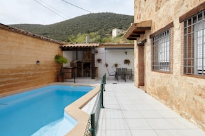 Une piscine, un espace extérieur aménagé pour se détendre et une vue sur les montagnes.