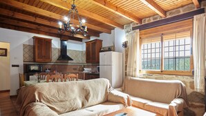 Un salon confortable avec un canapé, une table basse et un coin cuisine équipé de placards et d’une cuisinière.