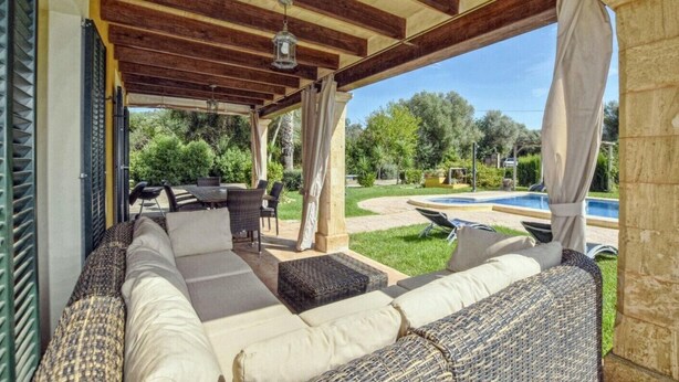 An outdoor covered patio with a sofa, chairs, and a pool. - Holiday Home 'Ines' with Mountain View, Wi-Fi and Air Conditioning (Inca)