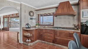 Una cocina con armarios de madera, horno empotrado y vistas a las montañas.