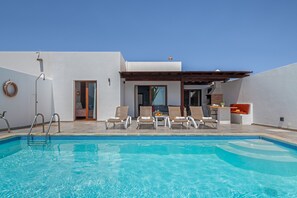 A swimming pool with lounge chairs and a covered seating area. - Vacation Home 'Bay View Villa' with Private Pool, Private Terrace, Air-conditioning and Wi-Fi (Playa Blanca)