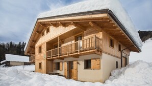 Eine Holzhütte mit Balkon, umgeben von Schnee.