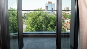 Un balcón con vistas a la ciudad, que incluye edificios y árboles.