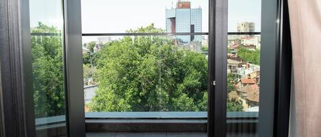 A balcony with a city view, including buildings and trees.