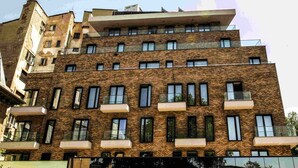 Un edificio de varios pisos con fachada de ladrillo, múltiples balcones y una variedad de estilos de ventanas.