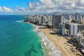 Un paisaje urbano costero con una playa, edificios altos y cielos despejados.