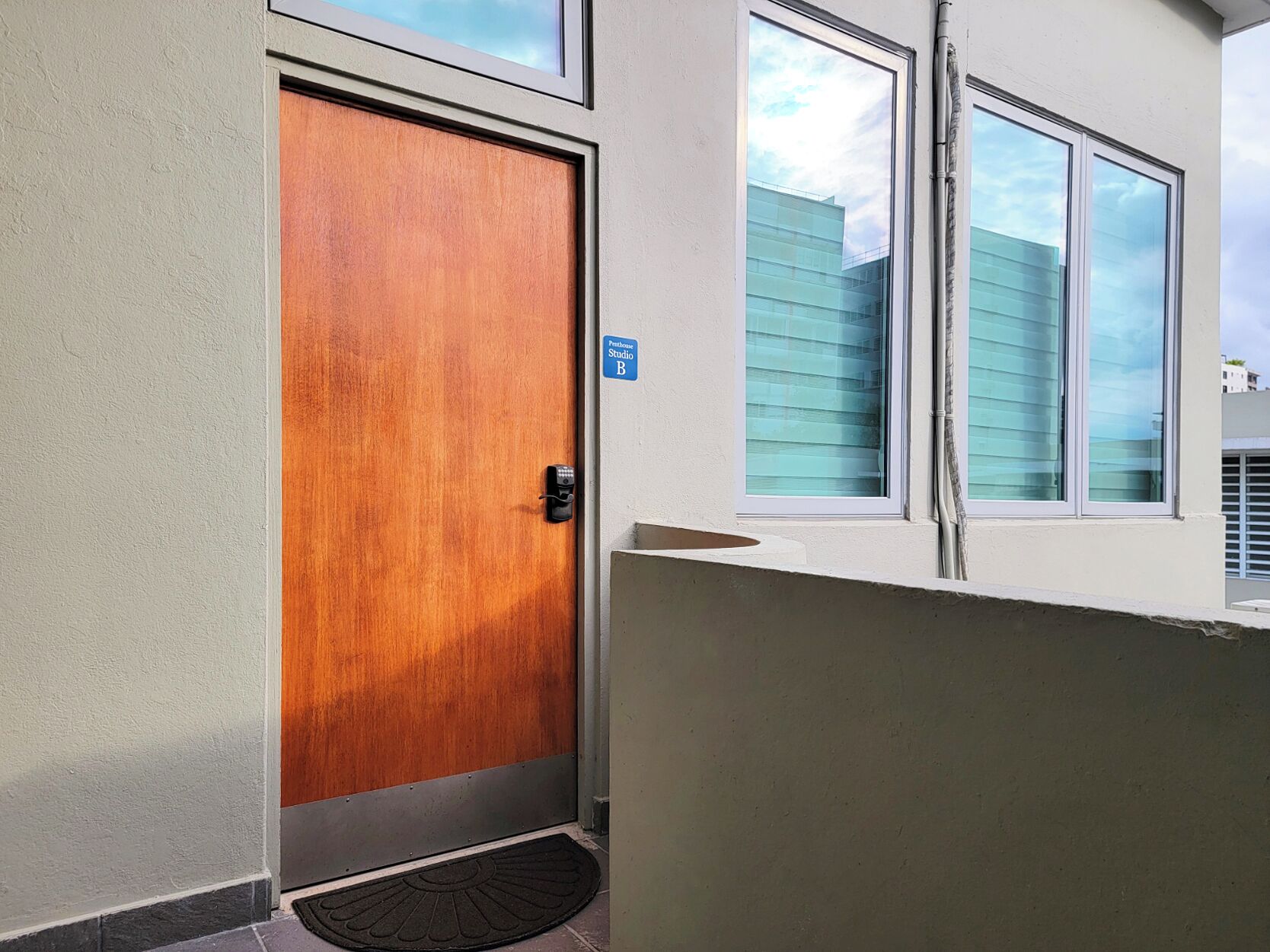A wooden door with a blue sign indicating a studio apartment.