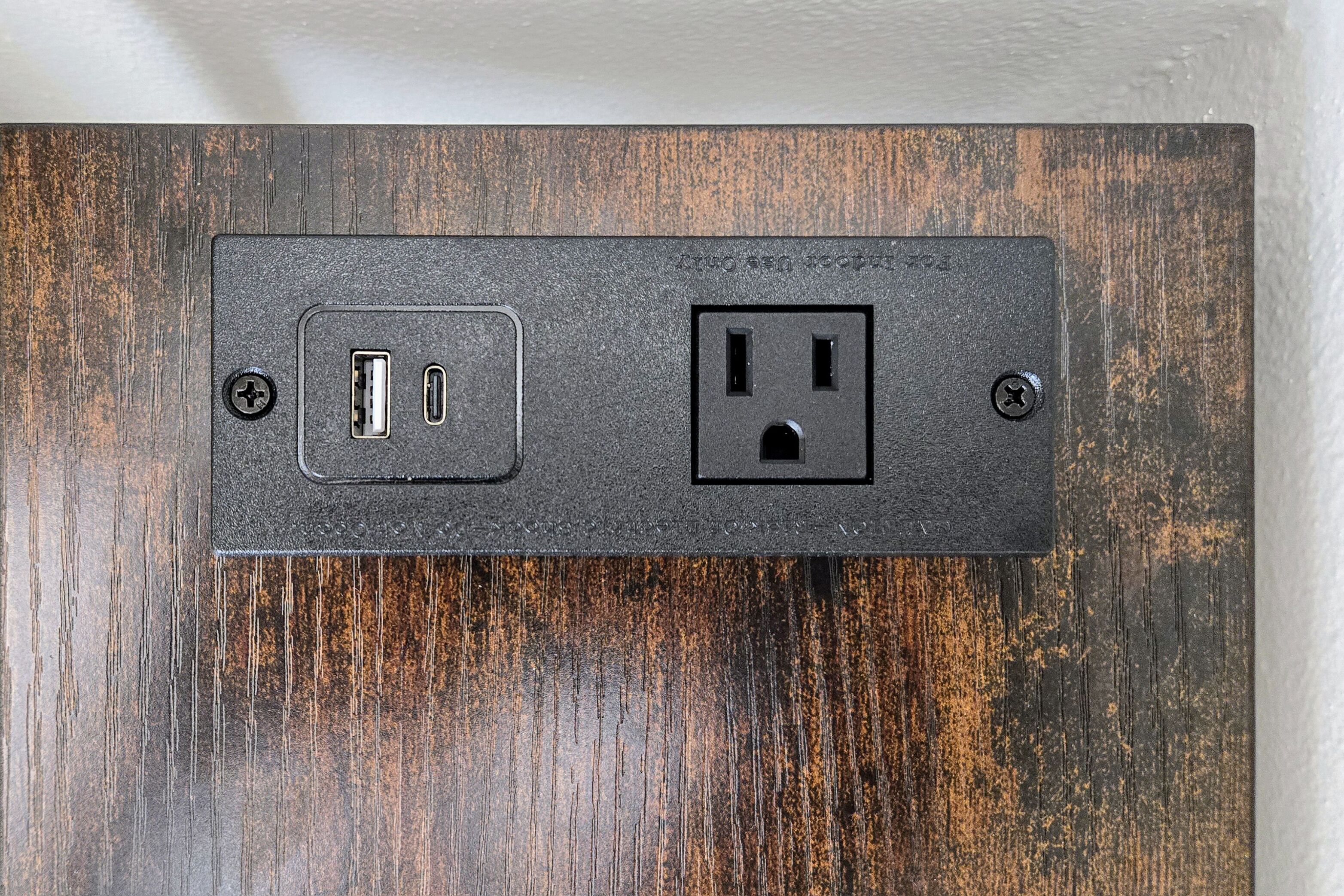 A wall-mounted electrical outlet with a USB port and a standard outlet.