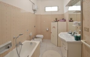 A bathroom with a bathtub, toilet, and sink.