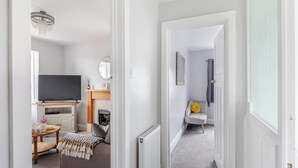 A modern living room with a television, fireplace, and seating area. - 1 bedroom accommodation in Torquay (Torquay)