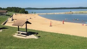 A beach with a picnic shelter, a sandy area, and a calm lake. - Stunning Condo Near Lake 2BR 2BA  right in Branson! Sleeps 6 .  (Branson)