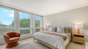 Relax in a serene space with a large bed, two nightstands, and a comfortable armchair.