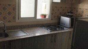 Eine Küche mit Fenster, Spüle, Herd und Schränken.