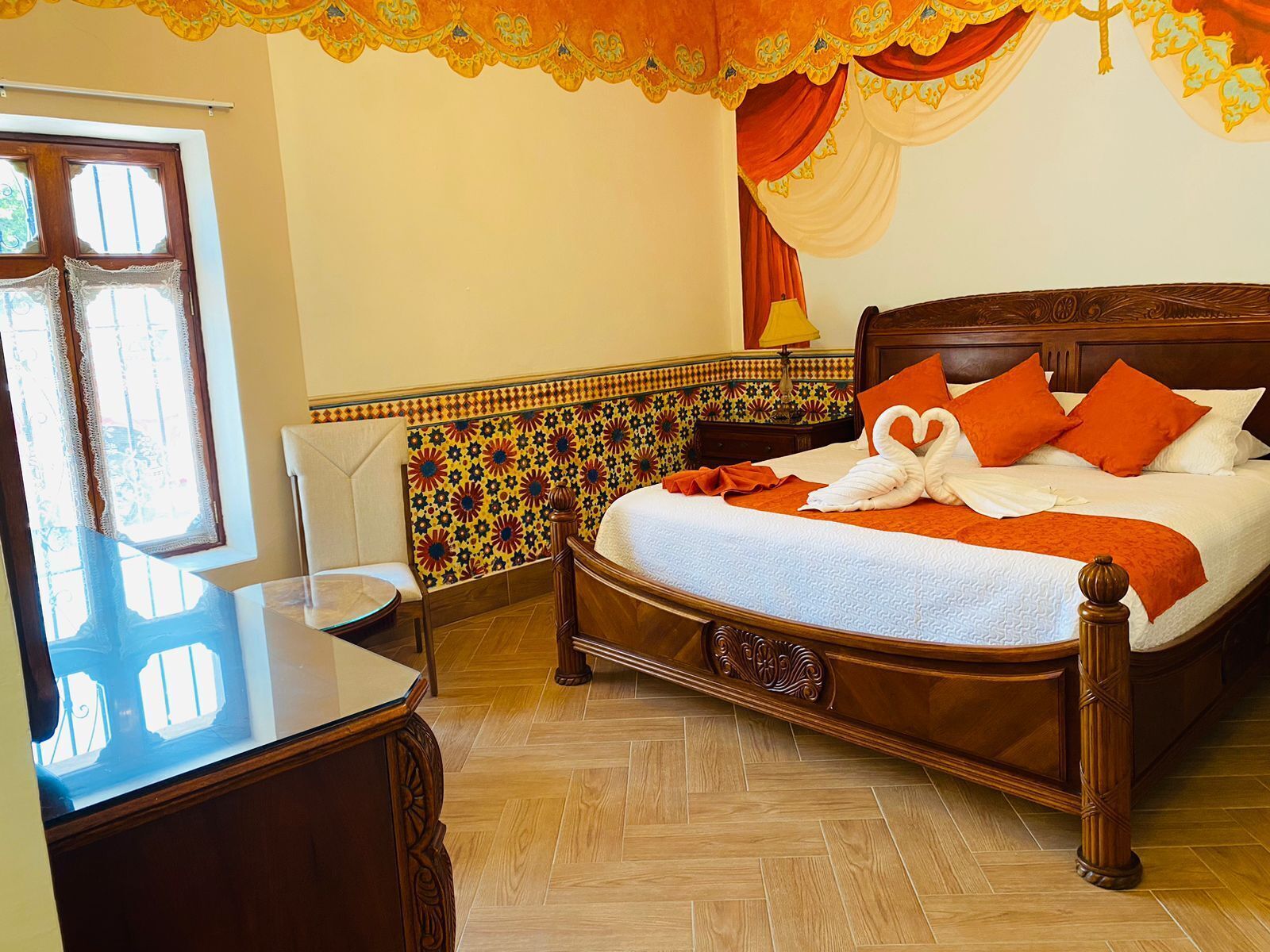A neatly arranged bedroom with a wooden bed, a bedside table, and a chair.