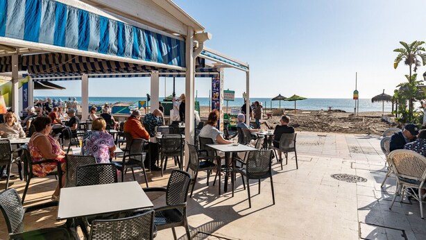 An outdoor café with tables and chairs, overlooking the beach. - MalagaSuite Costa Sol Oasis 3 (Torremolinos)