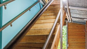 Eine Holztreppe mit Metallgeländern, die zu einer Tür führt.