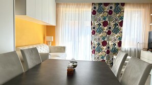 Ein Essbereich mit Tisch, Stühlen, einer Couch und einem Fernseher.