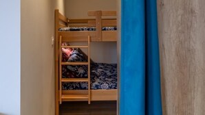 A narrow hallway leading to a bunk bed room with a wooden ladder and a blue curtain. - L'alticime - LA Feclaz LES Deserts (LA FECLAZ LES DESERTS)