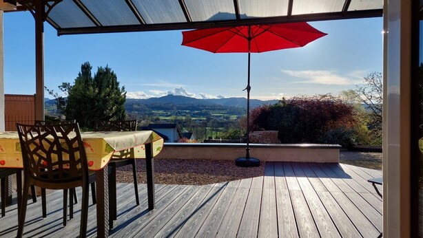 An outdoor patio with a table and chairs, a red umbrella, and a view of a valley with mountains in the background. - LA Marmotte - Saint Beron (SAINT BERON)