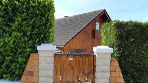 A wooden barn with a sloped roof, surrounded by a stone wall and a wooden gate. - LA Marmotte - Saint Beron (SAINT BERON)