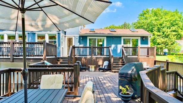 A deck with outdoor seating, a barbecue grill, and a covered umbrella. - Spacious Home! Game Room, Swing Set, Deck, Yard, Outdoor Fun + Sleeps 16 (Merriam)