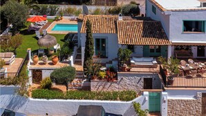 Une propriété résidentielle dotée d’une piscine, d’un espace extérieur aménagé et d’un mur en pierre.